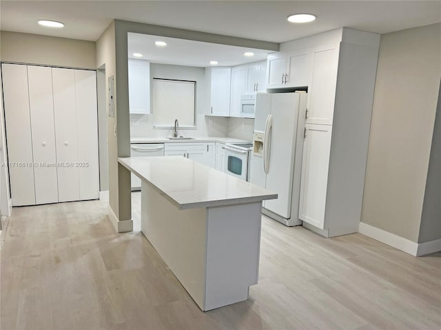 kitchen featuring sink, white cabinets, tasteful backsplash, light stone counters, and white appliances