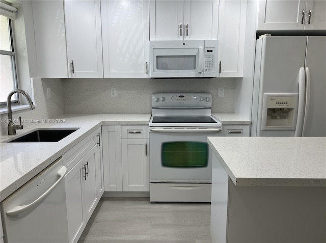 kitchen with sink, white appliances, backsplash, and white cabinets