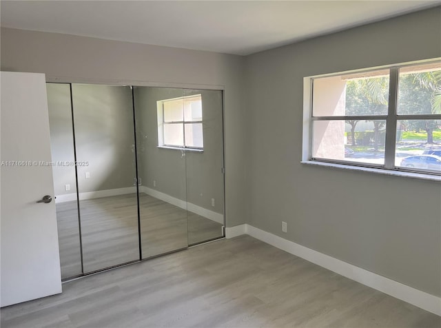 unfurnished bedroom with a closet and light hardwood / wood-style flooring