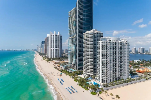 bird's eye view featuring a water view and a beach view