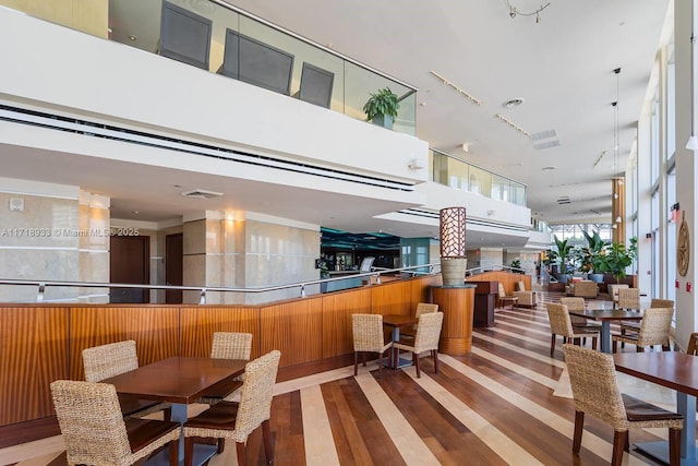 dining room featuring hardwood / wood-style floors and a towering ceiling