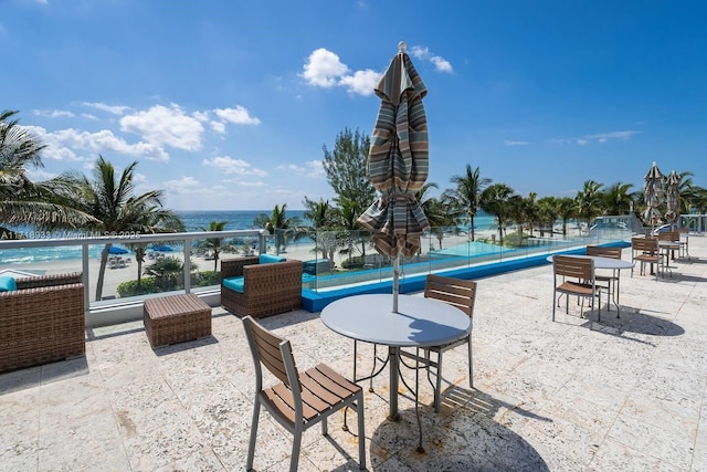 view of patio with a water view and tennis court