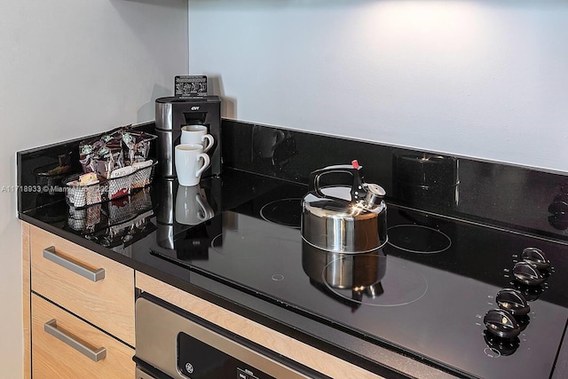 interior details with cooktop and light brown cabinets