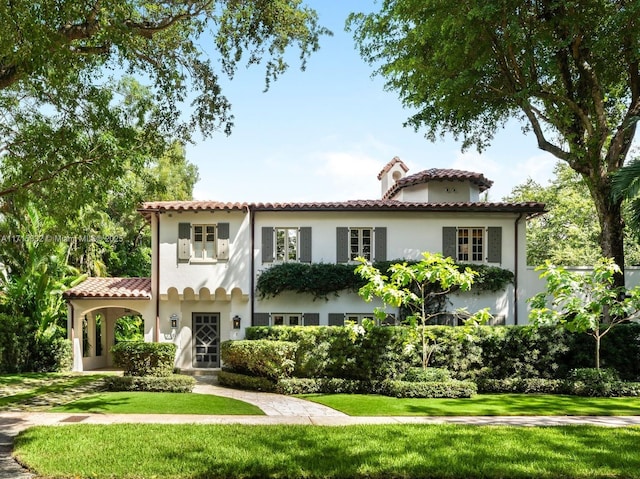 mediterranean / spanish-style home featuring a front yard