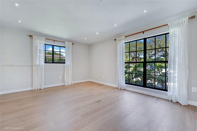 unfurnished room featuring a wealth of natural light and light hardwood / wood-style flooring