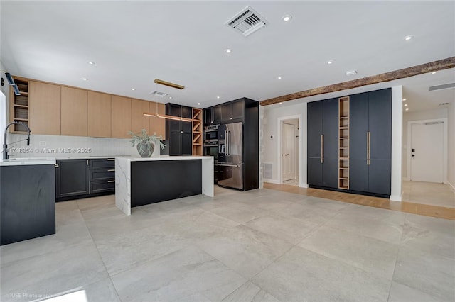 kitchen with sink, high end refrigerator, light brown cabinets, a kitchen island, and decorative backsplash