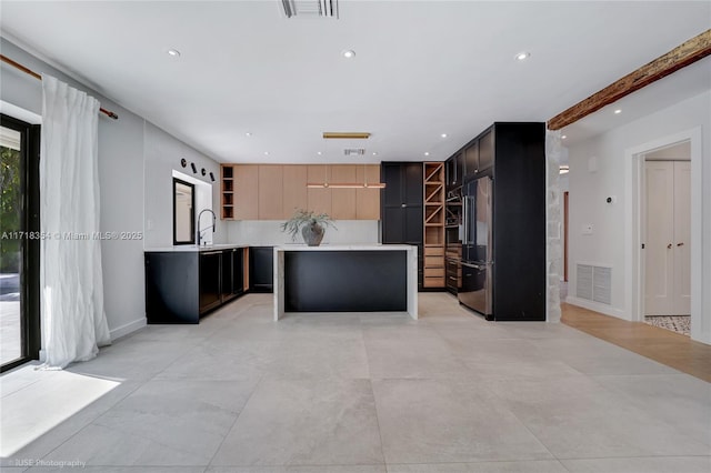 kitchen featuring high end fridge, a kitchen island, and sink