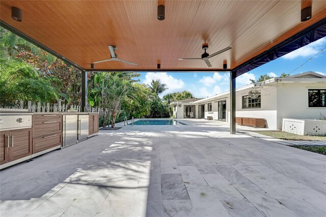 view of patio / terrace featuring ceiling fan and exterior kitchen