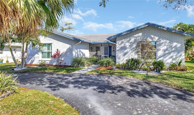 single story home featuring a garage and a front lawn