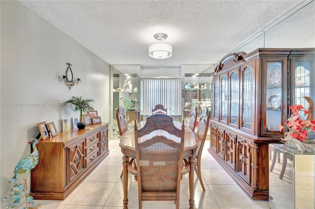 dining area with light tile patterned floors and a textured ceiling