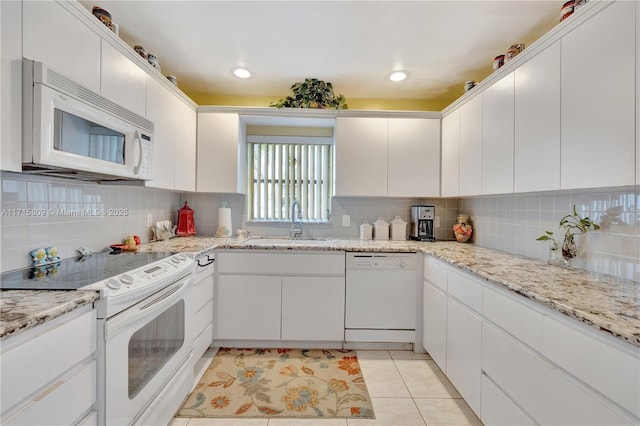 kitchen with white cabinets, sink, light tile patterned floors, and white appliances