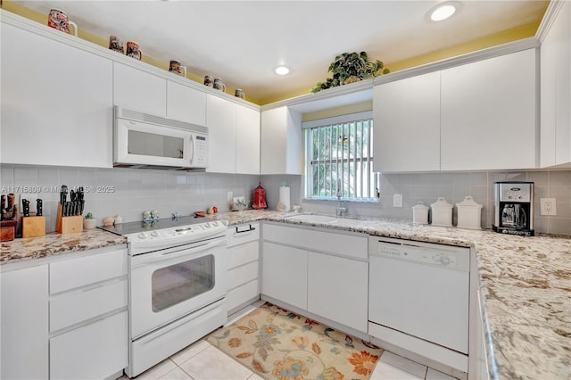 kitchen with white cabinets, white appliances, sink, and light tile patterned floors