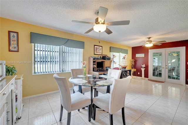 tiled dining area with ceiling fan, a textured ceiling, a wealth of natural light, and french doors