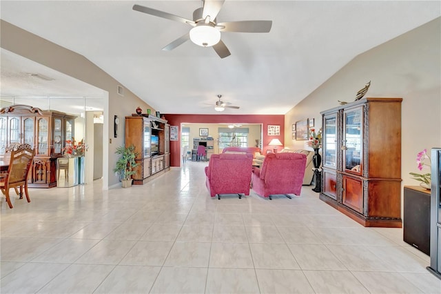 tiled living room featuring ceiling fan and vaulted ceiling