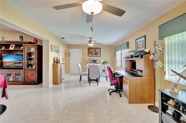 tiled office space featuring ceiling fan and a textured ceiling