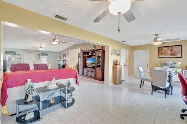 tiled living room with ceiling fan and a textured ceiling