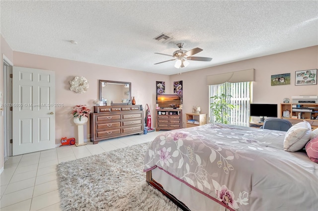 tiled bedroom with ceiling fan and a textured ceiling