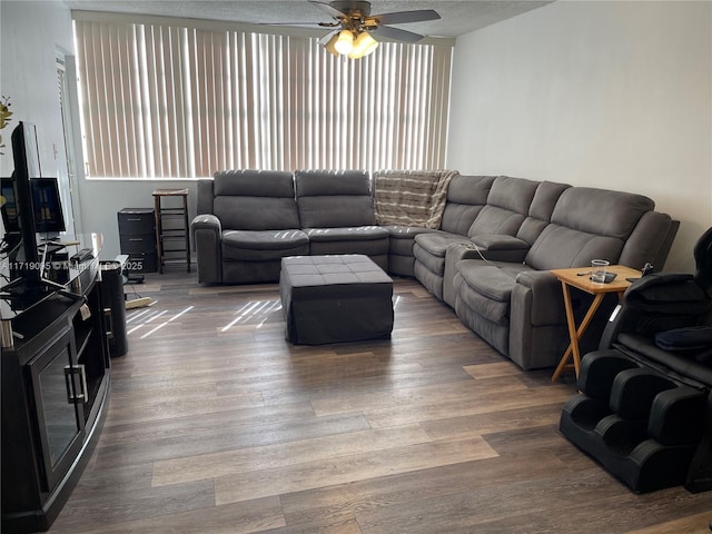 living room with ceiling fan, wood-type flooring, and a textured ceiling