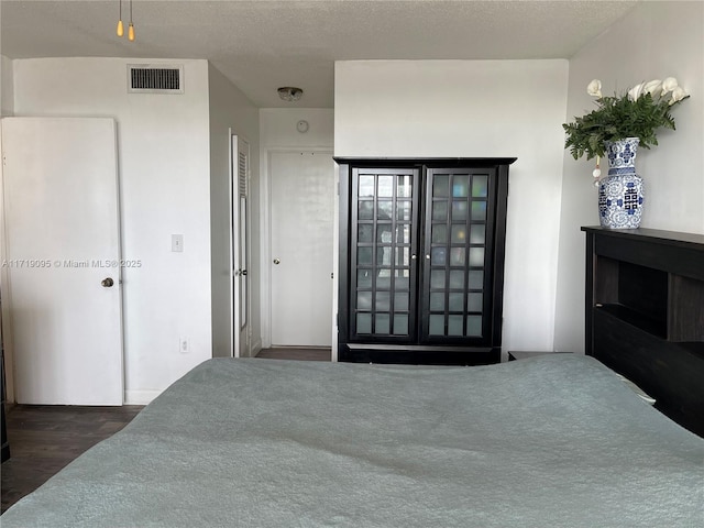 bedroom featuring dark hardwood / wood-style floors and a textured ceiling