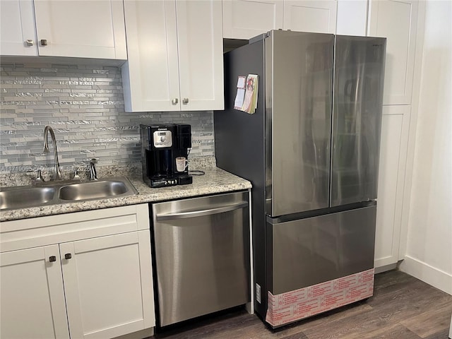 kitchen with dark wood-type flooring, sink, appliances with stainless steel finishes, tasteful backsplash, and white cabinetry