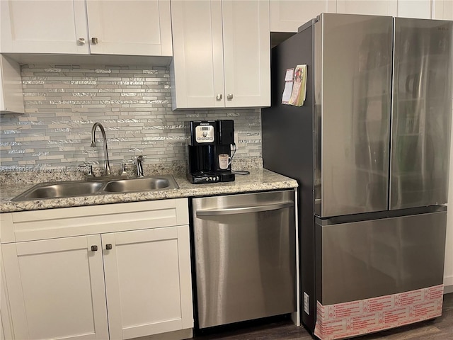 kitchen featuring backsplash, sink, appliances with stainless steel finishes, dark hardwood / wood-style flooring, and white cabinetry