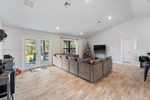 living room featuring french doors, light hardwood / wood-style floors, and vaulted ceiling