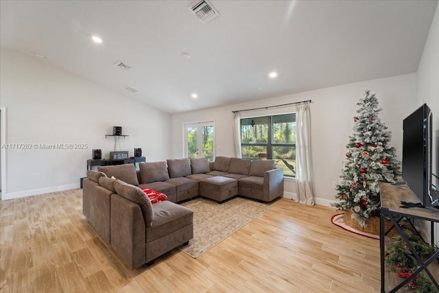 living room featuring light hardwood / wood-style floors and vaulted ceiling