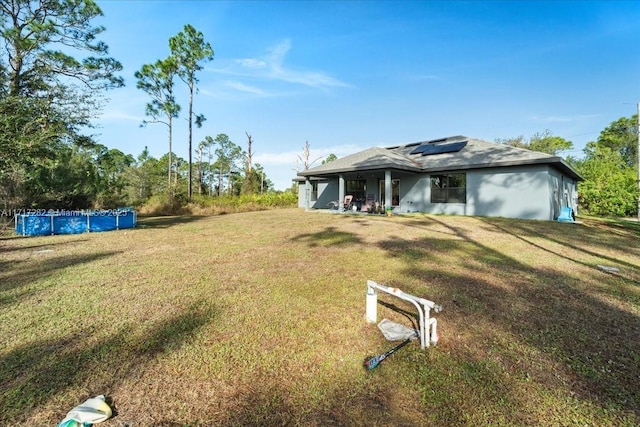 view of front facade featuring solar panels and a front yard