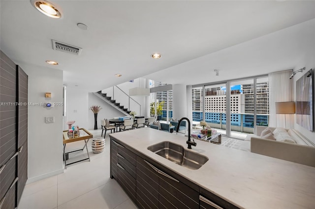 kitchen with floor to ceiling windows, light tile patterned floors, and sink