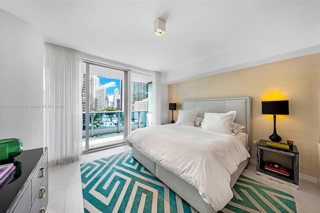 bedroom featuring access to exterior, light tile patterned floors, and a wall of windows