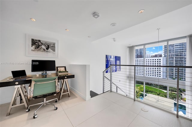 office space with tile patterned floors, floor to ceiling windows, and a healthy amount of sunlight