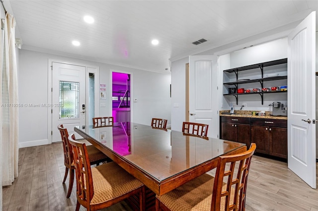 dining space featuring crown molding and light hardwood / wood-style floors