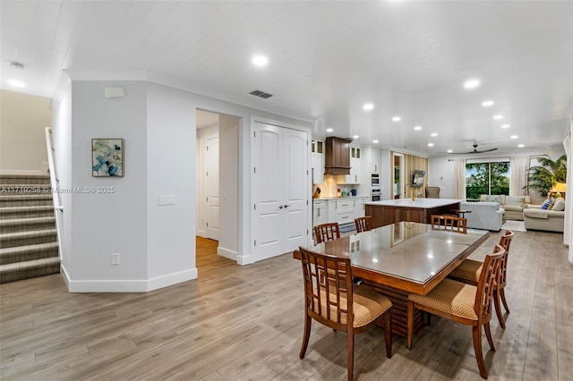 dining area with ceiling fan, light wood-type flooring, and crown molding