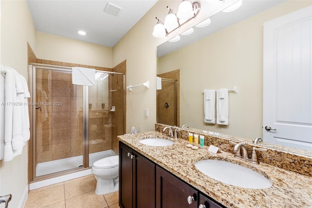 bathroom featuring toilet, vanity, tile patterned floors, and a shower with door