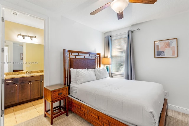 bedroom with ceiling fan, light tile patterned flooring, sink, and connected bathroom