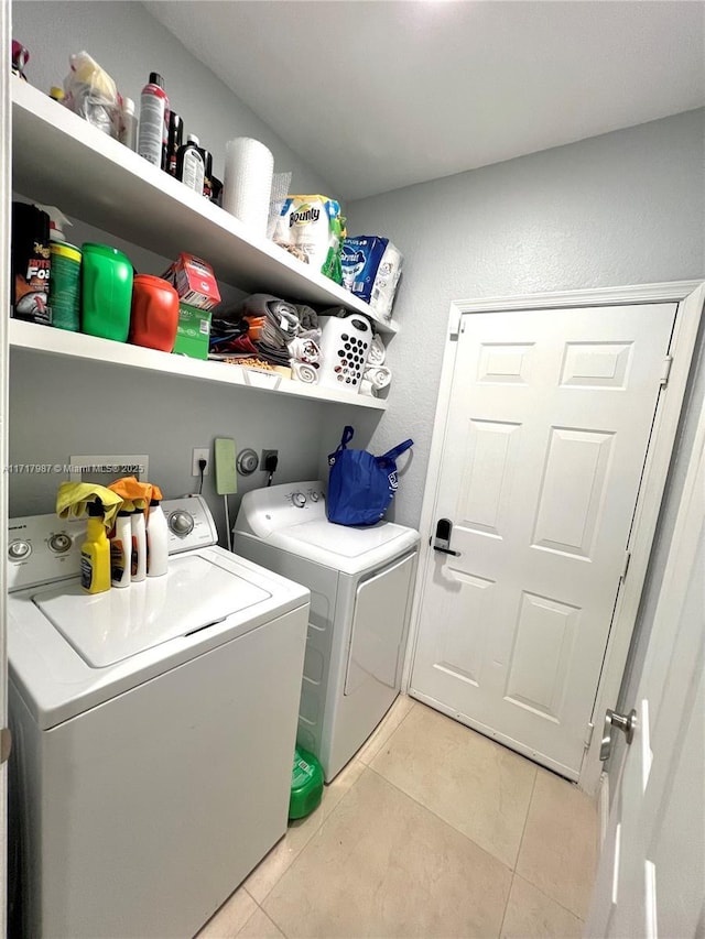 clothes washing area featuring washing machine and dryer and light tile patterned floors