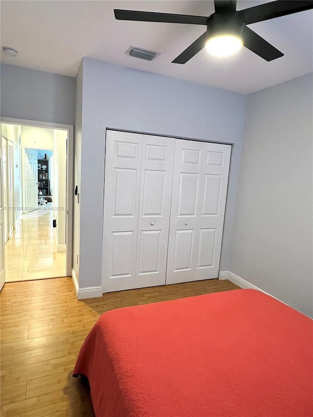 bedroom with hardwood / wood-style floors, ceiling fan, and a closet