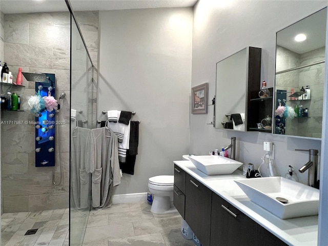 bathroom featuring vanity, toilet, and tiled shower