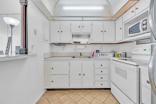 kitchen featuring sink, white cabinets, white appliances, and light tile patterned floors