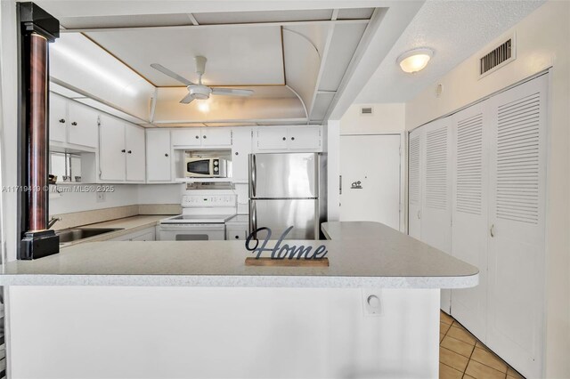 kitchen featuring white cabinets, light tile patterned floors, ceiling fan, stainless steel appliances, and a textured ceiling