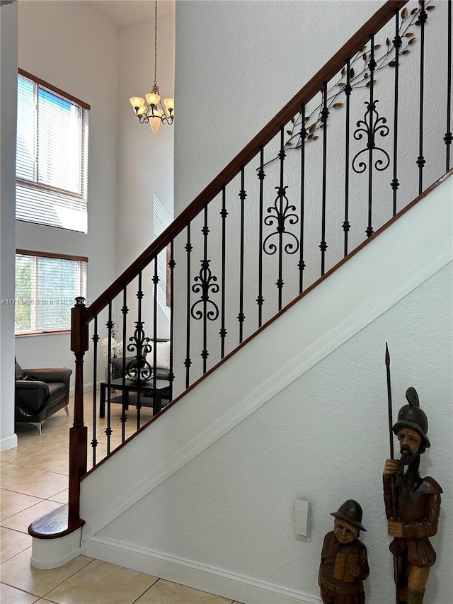 staircase featuring a chandelier and tile patterned floors