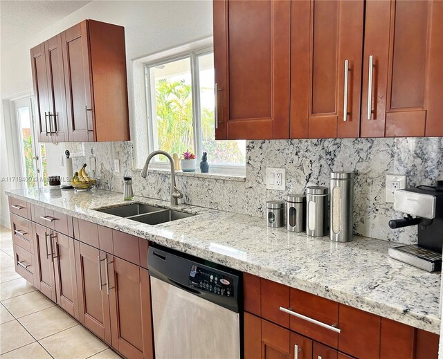 kitchen featuring tasteful backsplash, light stone countertops, sink, and stainless steel dishwasher