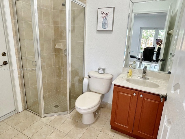 bathroom with tile patterned floors, vanity, toilet, and a shower with shower door