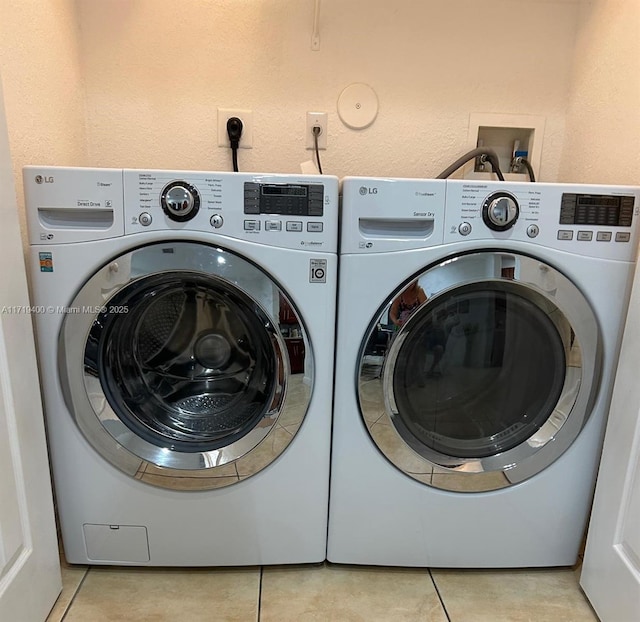 laundry area featuring light tile patterned floors and washer and clothes dryer