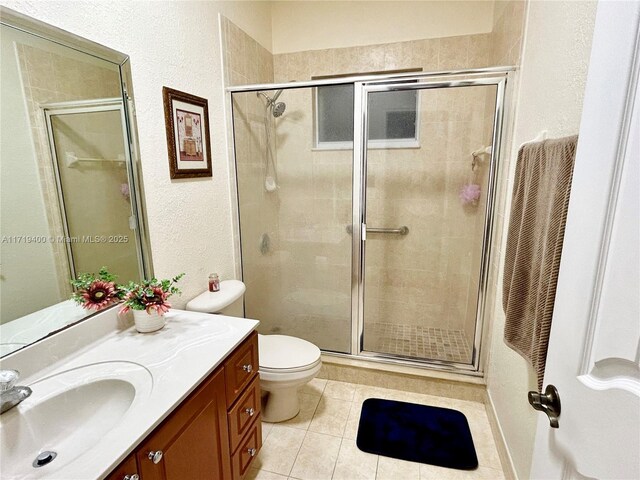 bathroom featuring toilet, vanity, and a shower with door