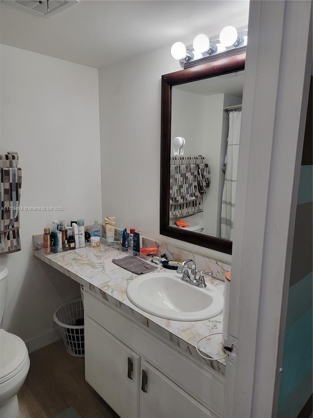 bathroom with vanity, hardwood / wood-style floors, and toilet