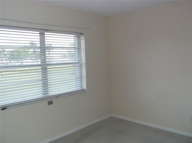 2850 W Golf Blvd Unit 215, Pompano Beach, FL 33064 - unfurnished room featuring baseboards, plenty of natural light, and light colored carpet