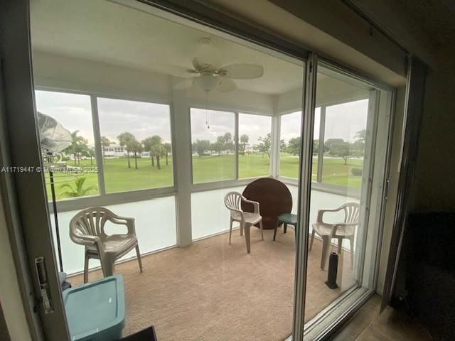 sunroom / solarium with a ceiling fan and plenty of natural light