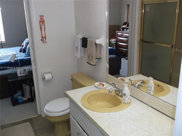 bathroom featuring tile patterned floors, vanity, toilet, and walk in shower