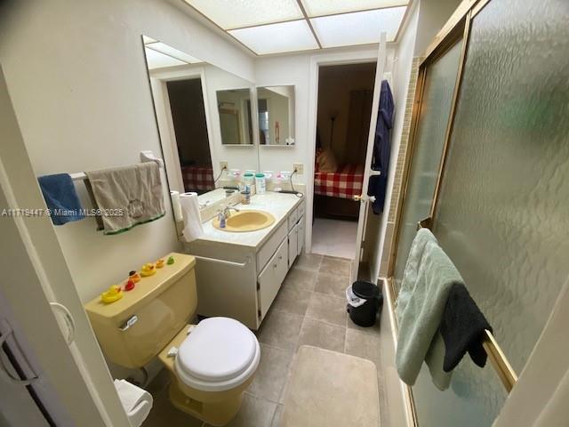 ensuite bathroom featuring toilet, a shower with shower door, ensuite bathroom, tile patterned flooring, and vanity